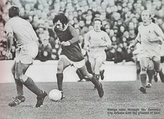 an old black and white photo of men playing soccer in front of a large crowd