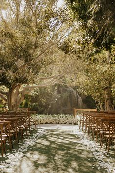 an outdoor ceremony set up with wooden chairs