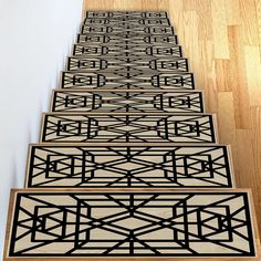 a set of three black and white stair mats on wooden steps with wood flooring