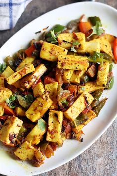 a white plate topped with tofu and vegetables