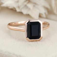 a black diamond ring sitting on top of a white blanket