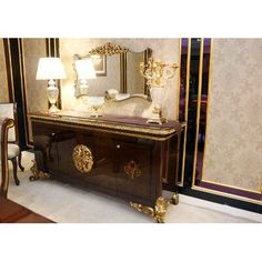 an antique dresser and mirror in a room with gold trimmings on the walls