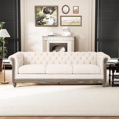 a living room filled with furniture and a white rug on top of a hard wood floor