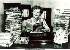 a man sitting in front of a pile of books