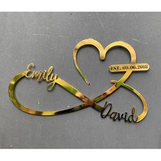 two heart shaped metal nameplates with the words happily and david in gold on a gray background