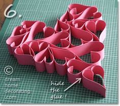 paper hearts laid out on a cutting board with instructions for how to fold them together