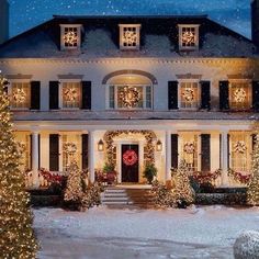 a christmas house with lights and wreaths on the front