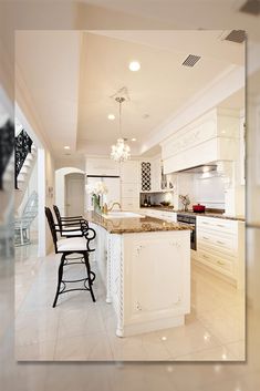 a large kitchen with white cabinets and marble counter tops, along with two bar stools