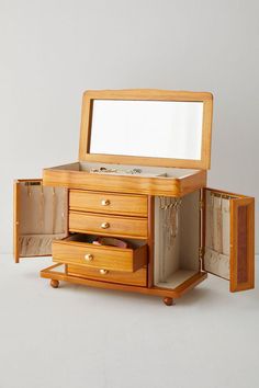 a wooden jewelry box with two drawers and a mirror on the top, in front of a white background