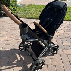 a stroller with a baseball bat attached to it's handlebars on a brick walkway