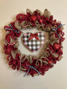 a burlap wreath with a heart hanging on the wall