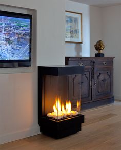 a television mounted on the wall next to a fire place in a room with hardwood floors