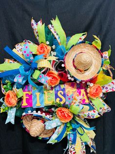 a colorful wreath with the word fiesta written on it and two straw hats attached to it