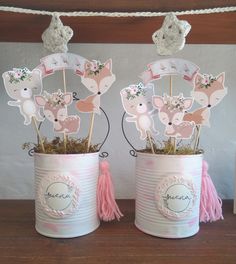 two tin cans with cupcake toppers in them