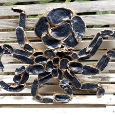 a metal sculpture sitting on top of a wooden bench