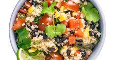 a bowl filled with rice, black beans, corn and cilantro garnish