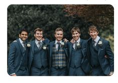 a group of men standing next to each other wearing suits and ties with flowers on their lapels