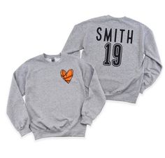 Step up your style game with this personalized crewneck sweatshirt! Our custom crewneck sweatshirt comes with a cute pocket size  basketball heart on the front. But that's not all - the customization doesn't stop there. We've also added a custom name and or number on the back, giving this sweatshirt a personalized touch. Stay cozy, make a statement, and showcase your individuality with our one-of-a-kind crewneck sweatshirt. If you like your sweatshirts loose or oversized, you might want to order a size up and if you'd like a more fitted look then order a size down. WE RECOMMEND MEASURING YOUR FAVORITE FITTING SWEATSHIRT AND COMPARING TO THE MEASUREMENTS ON THE SIZE Chart.  These are Gildan brand sweatshirts.  **Ships with in 3-7 business days** Every tee is handmade to order with love. Ple Basketball Heart, Brand Sweatshirts, Custom Crewneck Sweatshirts, Basketball Sweatshirts, Custom Crewneck, Mom Crewneck, Custom Basketball, Basketball Mom, Basketball Player