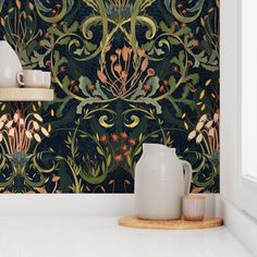 a vase and some cups on a shelf in front of a wallpapered background