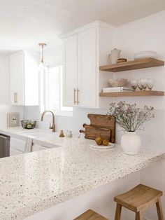 a kitchen with white counter tops and wooden stools