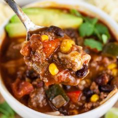 a spoon full of chili and corn soup