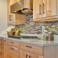 a kitchen with wooden cabinets and granite counter tops, along with an oven hood over the stove