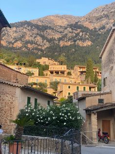 an old town with mountains in the background and a bicycle parked on the street next to it