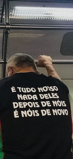 a man wearing a black shirt with white writing on it