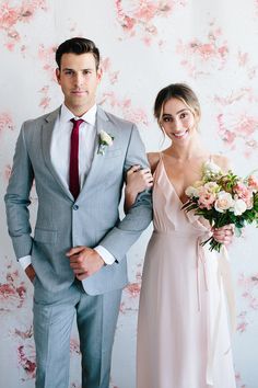 a man in a suit and tie standing next to a woman wearing a wedding dress