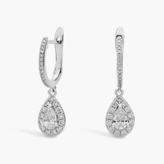 A pear diamond surrounded by a brilliant halo drips like a drop of morning dew from these 14k white gold drop earrings giving them a luxurious look that transcends the trends with its timeless style. White Gold Drop Earrings, Morning Dew, Diamond Drops, Diamond Drop Earrings, Pear Diamond, Pear Shaped Diamond, Spring Trends, Gold Drop Earrings, Diamond Fashion