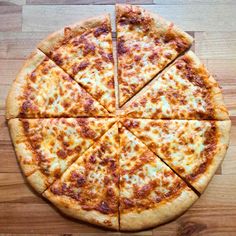 a sliced pizza sitting on top of a wooden table