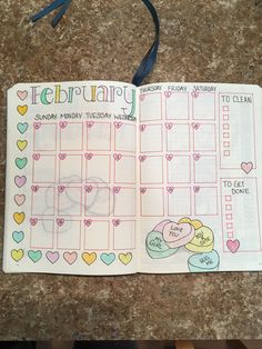 an open planner with hearts on it and the words february written in cursive writing