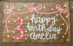 a birthday banner with the number three on it and pink ribbon around the letter'3, happy birthday amelia '