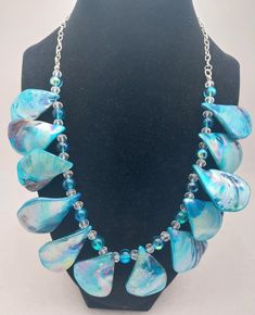 Victoria NC080, a Dramatic Statement Necklace made with Aqua Dyed Shell Beads, accented with Aqua Smooth Glass Beads and Clear Faceted Crystal Beads. Makes a Beautiful Addition to Your Summer Outfits! Also, a Lovely Gift! Blue Necklaces With Polished Beads, Bohemian Blue Shell Necklace For Jewelry Making, Blue Shell Necklace As A Gift, Unique Blue Beaded Necklace With Dangling Beads, Unique Blue Shell Necklace As Gift, Bohemian Blue Shell Necklace With Round Beads, Unique Blue Shell Necklace For Gifts, Unique Blue Beaded Necklace For Beach, Unique Blue Beaded Necklace For The Beach