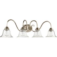 three light bathroom fixture with glass shades on the sides and an old - fashioned metal finish