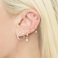 a woman with blonde hair wearing three different ear piercings