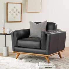 a black leather chair sitting on top of a white rug