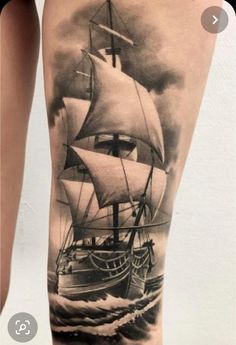 a woman's leg with a ship tattoo on it