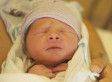 a close up of a baby wearing a hat