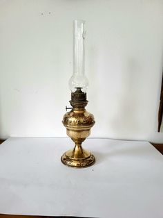 an old fashioned lamp is sitting on top of a white sheet and has a clear glass bulb