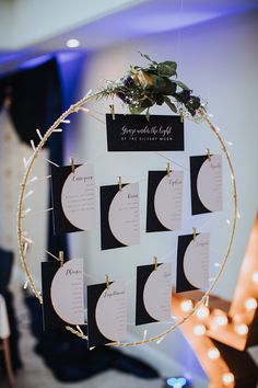 a table with place cards and lights on the wall in front of it that says save the date