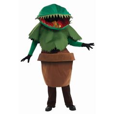 a man dressed as a dinosaur standing next to a pot with food in it's mouth