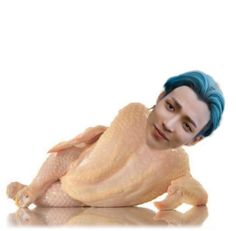 a man with blue hair laying on the ground next to a fake chicken in his hands