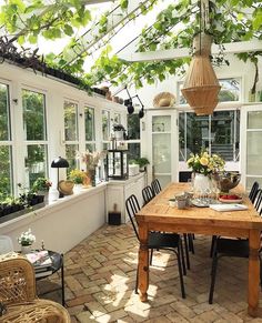 a table and chairs in a room filled with potted plants on top of it