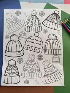 a coloring book with hats on it next to colored pencils