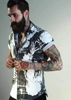 a bearded man with tattoos on his arms