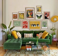 a living room with green couches and pictures on the wall