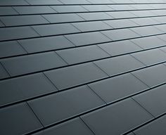 a close up view of a roof made of gray tiles with no visible shingles