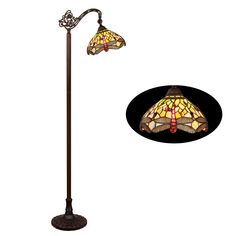 a lamp that is sitting on top of a floor next to a black circle with an image of a dragonfly on it