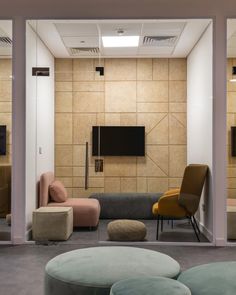 a living room filled with furniture and a flat screen tv mounted to the side of a wall